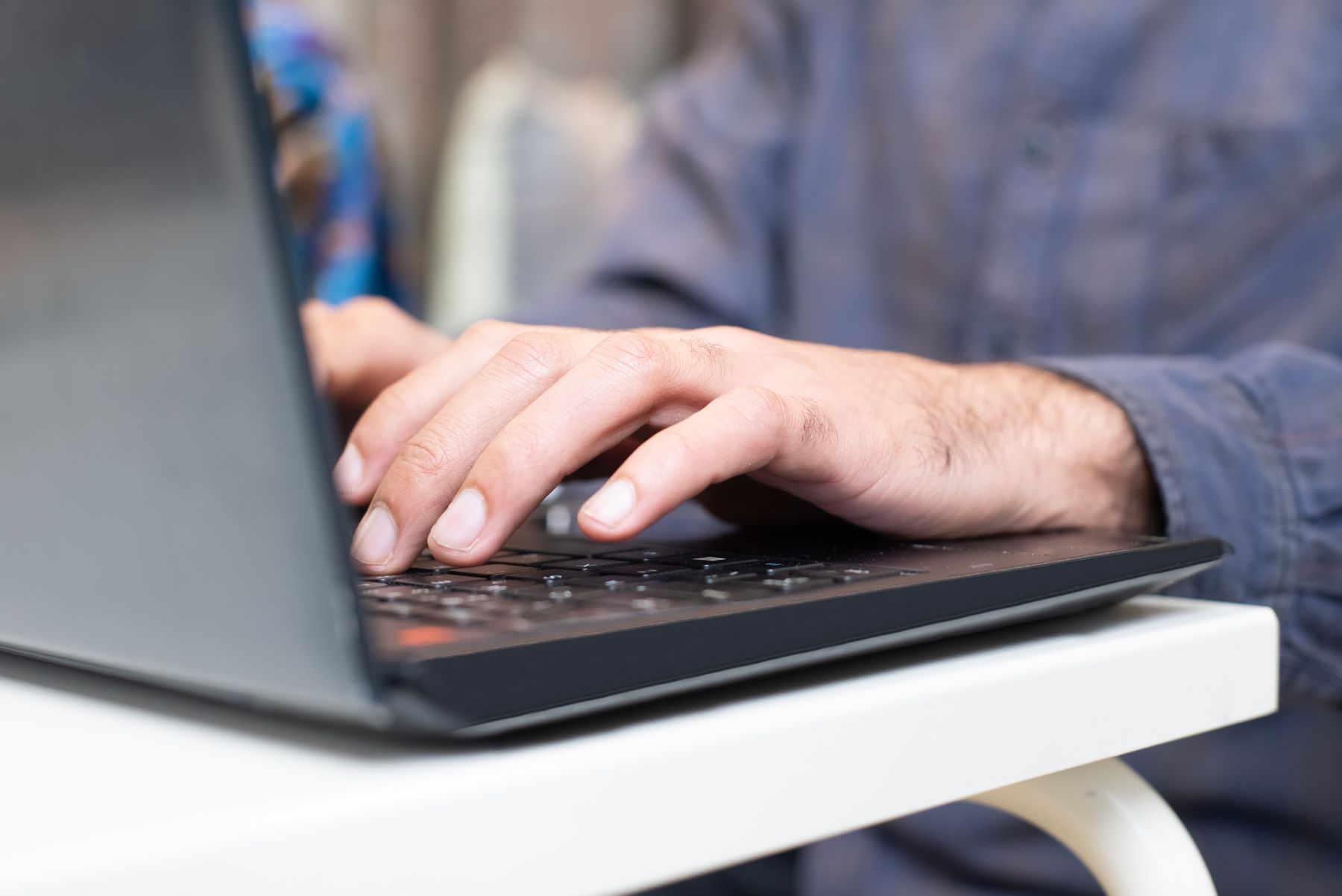 Handen die een vraag typen op een laptop
